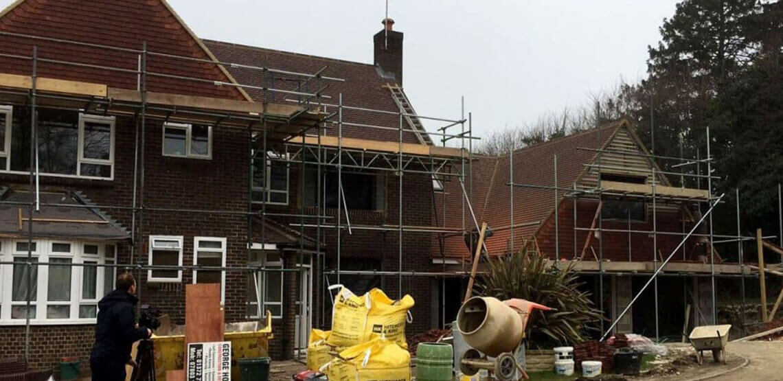 Exterior of Redbrick House with Scaffolding and Building Equipment Outside