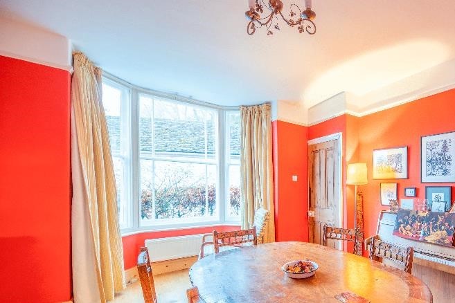 Red-themed Dining Room With Bay Window